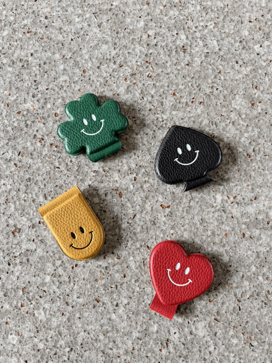 Four colorful Smile Magnet Money Clips on a terrazzo surface